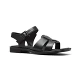 Sandalias bajas de cuero color marrón, con tiras anchas sobre el empeine, tira con hebilla al tobillo y suela plana.