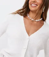 Cardigan blanco de punto con hilo mezclado, escote en V, abotonado frontal con botones forrados y mangas largas.