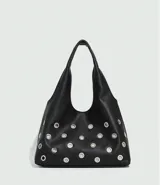 Bolso tipo hobo de cuero sintético negro con apliques de ojales metálicos plateados.