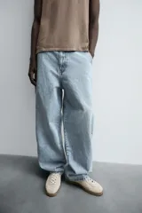 Pantalón de denim de algodón, color celeste claro lavado, de corte relaxed fit con tiro alto, bolsillos frontales y bolsillos traseros de plastrón.