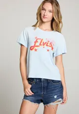 Remera celeste con estampa de la palabra "Elvis" en rojo y amarillo, con estrellas y un diseño de Sun Records.