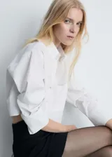 Minifalda negra de tiro medio con cinturón decorativo y cierre lateral.