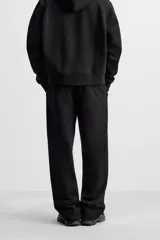 Pantalón jogger gris de corte recto, confeccionado en tejido de algodón compacto con interior en rizo. Cuenta con cintura elástica ajustable con cordón interior, bolsillos frontales y bolsillo de doble vivo en la espalda.