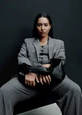 Blazer gris con raya diplomática, cuello con solapa, cierre frontal con botón y mangas largas abotonadas.