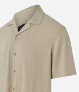 Camisa boxy masculina de viscosa color beige, con mangas cortas, cuello camisero y abotonadura frontal.