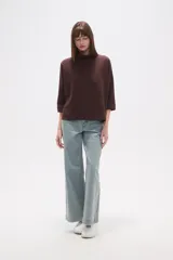 Polera holgada de poliéster color verde militar, con cuello alto tipo tortuga y mangas tres cuartos.