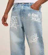 Pantalón baggy de jeans celeste con estampa de letras estilo grafiti en blanco.