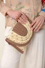 Sobre de rafia color beige y marrón con lurex dorado, con correa para colgar y lazo de mano.
