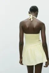 Vestido corto marrón con cuello halter con lazada y escote pico.
