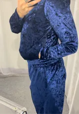 Conjunto deportivo de terciopelo azul, compuesto por campera con capucha y cierre frontal, y pantalón de corte ancho con cintura elástica.
