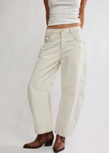 Pantalón de jean color crema, de corte relajado, piernas anchas y tiro medio. Tiene una silueta distinta y un largo hasta los tobillos.