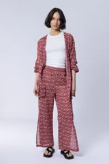 Conjunto de pantalón palazzo con aberturas laterales y kimono largo con estampado geométrico en tonos rosa y beige. Incluye un top blanco de algodón.