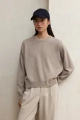 Suéter de punto liso, color gris oscuro, con cuello redondo y calce holgado.