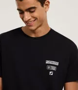 Remera negra de algodón con cuello redondo y mangas cortas. Presenta un estampado con texto y figuras geométricas en el lado superior derecho del frente.