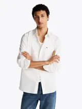 Camisa blanca de sarga de puro algodón teñido en prenda, con cuello con botones, bolsillo de parche en el pecho y puños redondeados con botón.
