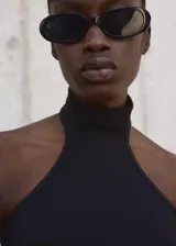 Top negro de punto fino con cuello halter y diseño entallado.