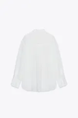 Camisa blanca con rayas verticales, cuello solapa, manga larga y cierre frontal con botones.