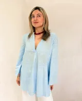 Blusa celeste de broderie con escote en V y mangas largas.