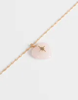Collar corto dorado con dije de corazón de cuarzo rosa y estrella dorada.