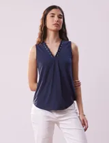Blusa azul marino sin mangas, de seda fría, con escote en V y detalle de lazo entrelazado con ojales metálicos.