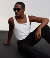 Musculosa blanca de rib con textura acanalada, escote cuadrado y breteles medianos. Confeccionada en algodón certificado BCI y elastano.