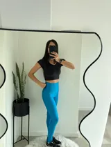 Conjunto deportivo azul con textura acanalada, compuesto por calzas largas de tiro alto y top deportivo con breteles anchos.