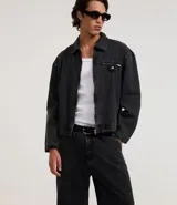 Pantalón de jeans para hombre, modelo super baggy, color negro con efecto marmoleado (acid wash). Presenta cintura con trabillas, cierre tradicional y bolsillos.