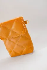 Cartera mini color rojo, capitoneada, porta celular y documentos, con correa regulable.