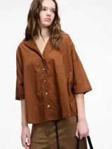 Camisa color crudo con botones en la parte delantera y mangas 3/4. Corte holgado.