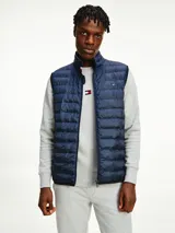 Chaleco acolchado azul marino con cierre de cremallera, cuello alto y logo de Tommy Hilfiger bordado en el pecho.