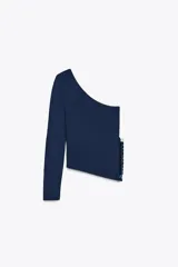 Jersey azul marino de punto con escote asimétrico y manga larga. Bajo asimétrico con aplicación de lentejuelas.