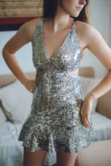 Vestido corto azul con estampado floral blanco, escote en V, breteles finos cruzados en la espalda, cut-outs laterales y volado en el ruedo.