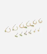 Set de seis pares de aros dorados con diferentes diseños: aros tipo argolla con dije rectangular verde, aros tipo argolla con dije rectangular transparente, aros tipo argolla lisa, aros con forma de rectángulo verde, aros con forma de rectángulo transparente y aros tipo botón con forma de esfera.