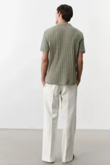 Remera polo verde salvia de punto texturizado, corte slim fit, manga corta, cuello clásico y tapeta con dos botones.