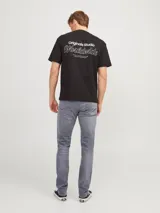 Jean de hombre gris con corte slim fit, cinco bolsillos y cierre con botón.