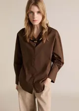 Camisa marrón de algodón con cierre de botones frontal, corte recto, cuello camisero y mangas largas con puños abotonados.