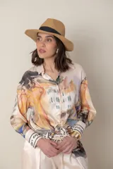 Camisa de satén de seda estampada, de color natural con estampado en tonos de naranja, verde y lilas, con puños anchos y terminación de guarda.