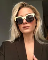 Lentes de sol cuadrados con armazón bicolor: parte superior color crema y parte inferior con estampado carey. Lentes polarizados negros con protección UV400.