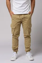 Pantalón cargo color beige de gabardina, con corte ajustado, bolsillos laterales con fuelle y puños elásticos en los tobillos.