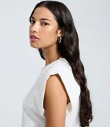 Blusa sin mangas, color blanco, confeccionada en tejido rib de algodón, con cuello redondo y hombreras marcadas.