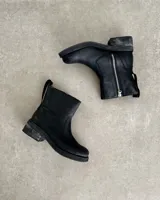 Botín marrón de cuero vacuno, con caña media, cierre lateral y suela de goma.