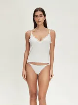 Conjunto de ropa interior gris melange, compuesto por musculosa de breteles finos y tanga con detalles de encaje blanco.