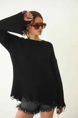 Sweater tejido color crudo, de manga larga con efecto desgastado y deshilachado en el ruedo y puños. Tiene cuello redondo y calce holgado.