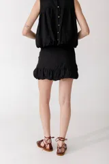 Minifalda color ladrillo con cintura alta y volados en el ruedo.