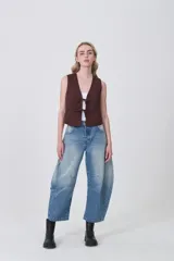 Chaleco sin mangas color marrón oscuro, de corte ajustado al cuerpo, con escote en V y cierre frontal mediante lazos anudados con detalles de cuentas oscuras.