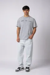 Remera gris con efecto lavado, cuello redondo y estampado con motivos de automovilismo.