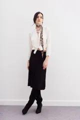 Falda midi negra de tejido de punto con cintura elastizada y diseño plisado.