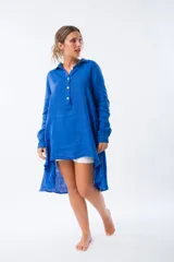 Camisa azul de lino con botones de nácar, corte amplio y largo irregular.