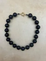 Collar de cuentas redondas de color negro y naranja alternadas.