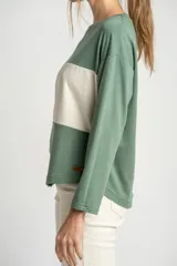 Sweater de mangas largas color verde con una franja horizontal color crema en el pecho.